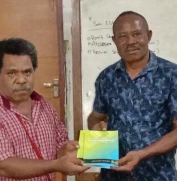 Engel Dimara Perwakilan Jerat Papua saat menyerahkan Buku kepada Sekretaris Dewan Adat Suku Berbay Mikha Runaweri foto : nesta/jeratpapua.org